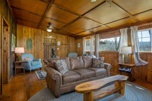 Deerwoode Reserve | Living room, wood paneling, couch.
