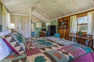 Deerwoode Reserve | Bedroom, cabin, wood paneling, quilt.